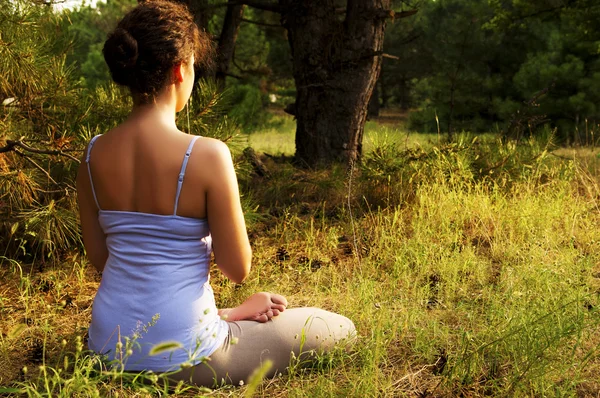 Genç kadın ormanda Yoga uygulamak — Stok fotoğraf