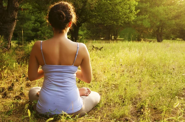 Genç kadın ormanda Yoga uygulamak — Stok fotoğraf