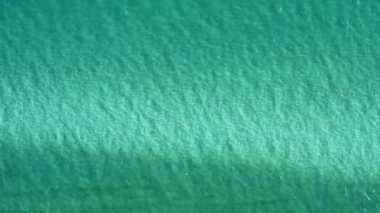 Su yüzeyi dokusu. Hareket temiz dalgalanmalar ve el sallama. Üst görünüm deniz kenarı, güneş ışığı su arka planı. Su arkaplanı