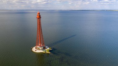 Stanislav-Adzhigol deniz feneri manzarada mavi gökyüzünde bulutlu suyla. Ukrayna.