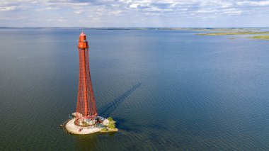 Stanislav-Adzhigol deniz feneri manzarada mavi gökyüzünde bulutlu suyla. Ukrayna.