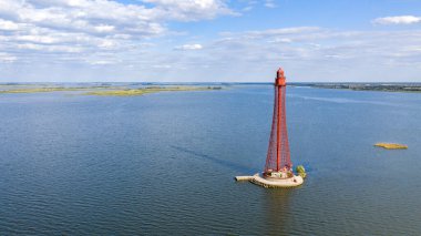 Stanislav-Adzhigol deniz feneri manzarada mavi gökyüzünde bulutlu suyla. Ukrayna.