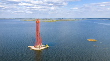 Stanislav-Adzhigol deniz feneri manzarada mavi gökyüzünde bulutlu suyla. Ukrayna.