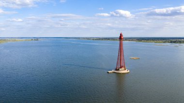 Stanislav-Adzhigol deniz feneri manzarada mavi gökyüzünde bulutlu suyla. Ukrayna.