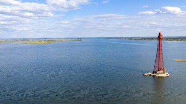 Stanislav-Adzhigol deniz feneri manzarada mavi gökyüzünde bulutlu suyla. Ukrayna.