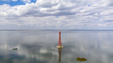 Stanislav-Adzhigol deniz feneri manzarada mavi gökyüzünde bulutlu suyla. Ukrayna.