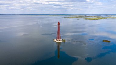 Stanislav-Adzhigol deniz feneri manzarada mavi gökyüzünde bulutlu suyla. Ukrayna.
