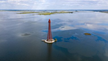 Stanislav-Adzhigol deniz feneri manzarada mavi gökyüzünde bulutlu suyla. Ukrayna.