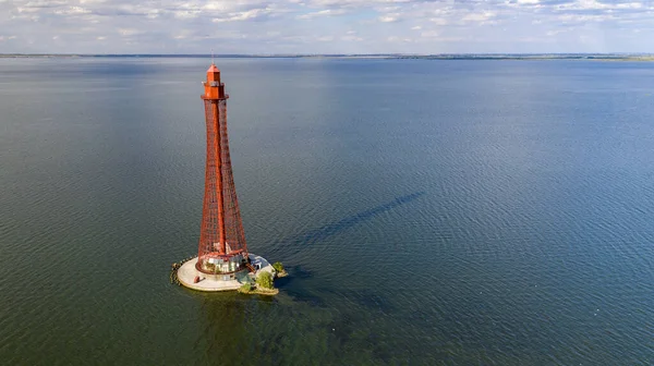 Stanislav-Adzhigol deniz feneri manzarada mavi gökyüzünde bulutlu suyla. Ukrayna.