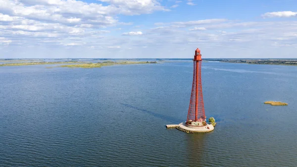 Stanislav-Adzhigol deniz feneri manzarada mavi gökyüzünde bulutlu suyla. Ukrayna.