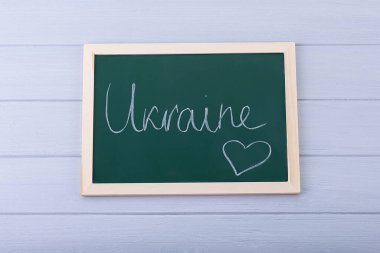 Yeşil bir karatahtaya beyaz tebeşirle yazılmış el yazısı.