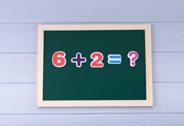 Manyetik numaraları olan okul yönetim kurulu. Örnekler çözülüyor. Çocuklar için Matematik