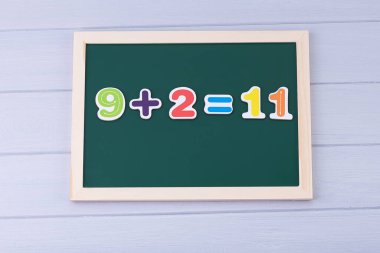 Manyetik numaraları olan okul yönetim kurulu. Örnekler çözülüyor. Çocuklar için Matematik