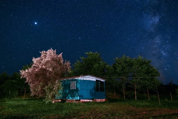 Abandoned old house at night at the background of the starry sky. Summer night.