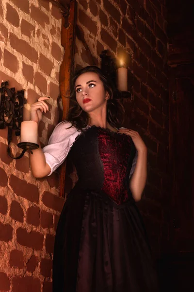夜の城で素晴らしい中世の女性 毛皮と金 長い髪のブルネットとロイヤルベルベットのヴィンテージの赤いドレス 夕暮れ — ストック写真