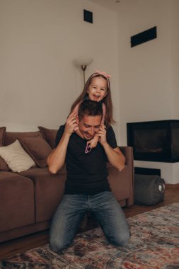 Güzel bir evde babasıyla oynayan küçük bir kız. 