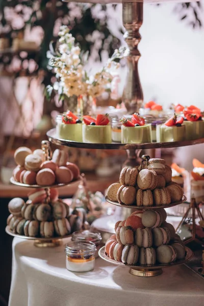 Lokantada şekerli büfe masası. Çiçeklerle süslenmiş bir yüzeyde kekler, pastalar, gurme şekerlemeler. 