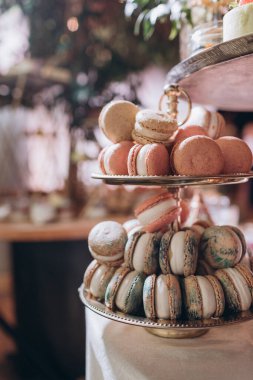 Lokantada şekerli büfe masası. Çiçeklerle süslenmiş bir yüzeyde kekler, pastalar, gurme şekerlemeler. 