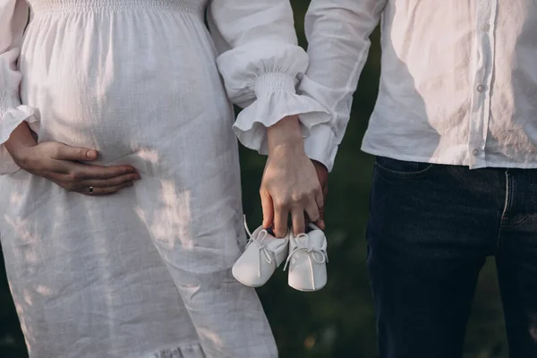 穿着漂亮衣服的年轻孕妇和她的丈夫在夏天的田野里散步 — 图库照片