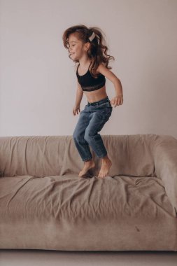 Küçük aktif kız koşuyor, zıplıyor ve eğleniyor 