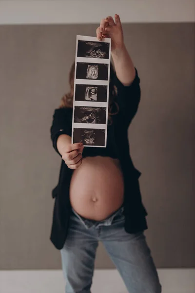 Hermosa Joven Embarazada Muestra Imágenes Del Futuro Bebé —  Fotos de Stock