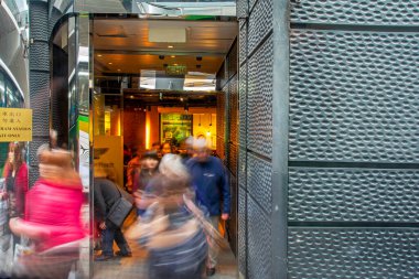 Hong Kong, Çin, SAR - 22 Şubat 2014: Metro istasyonuna gelen insanlarla dolu metro girişi. Hareket bulanıklığı, sokak fotoğrafçılığı. Dekoratif taş duvar yüzeyi