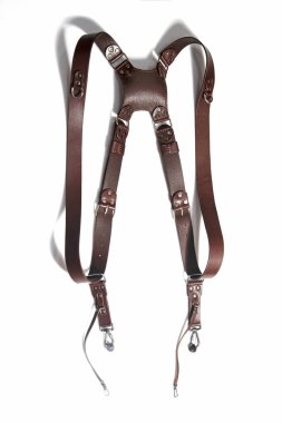 Kahverengi el, beyaz arka planda izole edilmiş nikel metal elementlerle doğal deri çift kameralı omuz askısı yapmış. Fotoğraf ekipmanları, şık, eski moda, eski moda