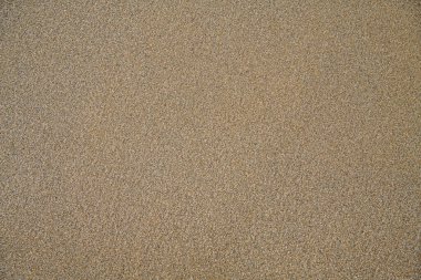 Arka plan için kumlu sahilin en üst görüntüsü. Doğal bej kumtaşı dokusu. Yaz için dalgalı kum desenleri, tatil tasarımları. Bir metin için yüzey, boşluk