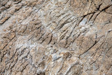 Dokuya yakın plan antik açık bej mermer ve çatlaklar. Doğal taş yüzey, tasarım ve duvar kağıdı arka planı için doku kullanımı. Granit soyut desen, doğa bilyesi. Metin için yüzey, boşluk