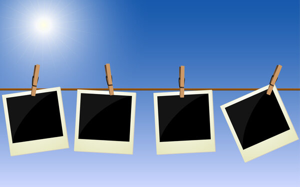 Четыре поляроидные картины, висящие на веревке на фоне яркого неба
