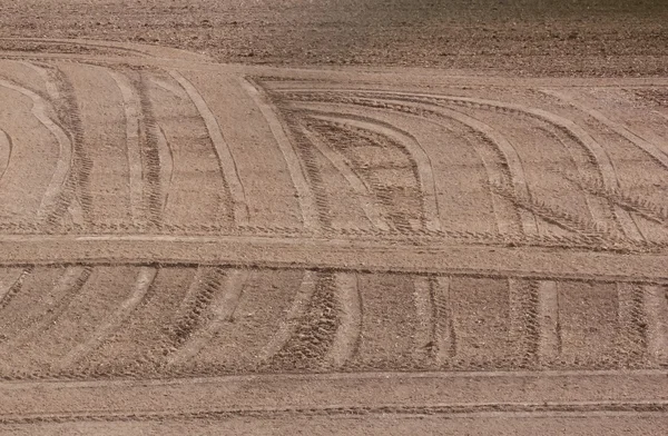 Земля в конце сбора урожая, следы шин трактора — стоковое фото