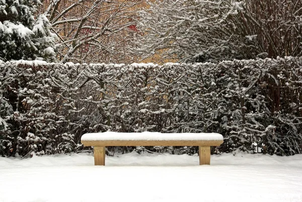 Bänk täckt med snö på vintern, i en allmän trädgård (Frankrike Europa) — Stockfoto