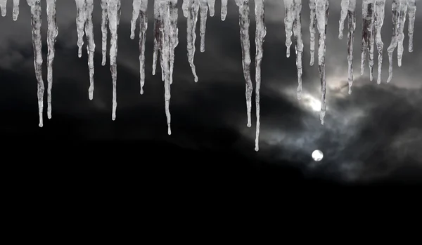 Eiszapfen am dunklen Winterhimmel — Stockfoto