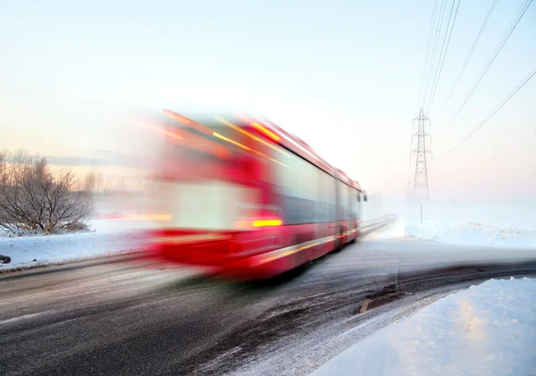 Ônibus vermelho em movimento turvo no inverno — Fotografia de Stock