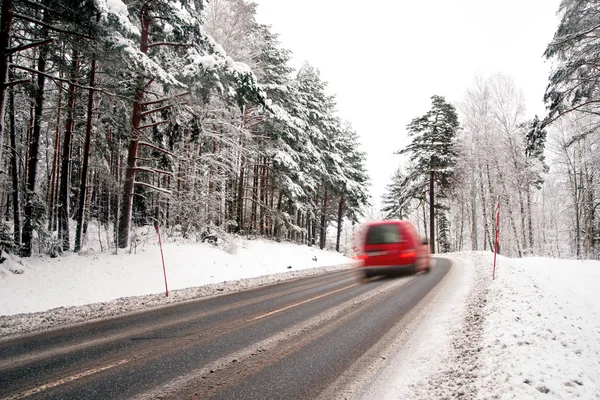 Красный фургон на зимней дороге — стоковое фото