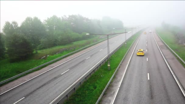 Snelweg met snelle verkeer op mistige ochtend — Stockvideo