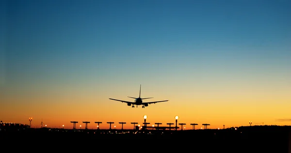 Aereo in avvicinamento all'aeroporto al tramonto — Foto Stock