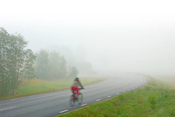 Велосипедна жінка в тумані — стокове фото