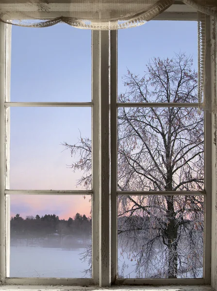 Matahari terbenam musim dingin dilihat melalui jendela lama — Stok Foto