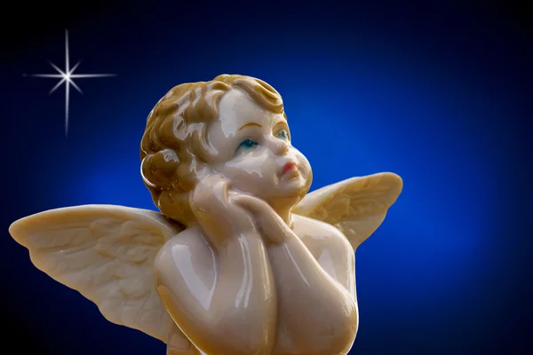 Porcelain angel on deep blue background — Stock Photo, Image