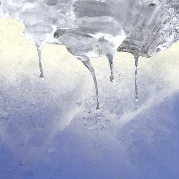 Eiszapfen auf blauem und gelbem Hintergrund — Stockfoto