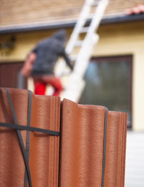 Pracownik wprowadzenie nowej dachówki na dom — Zdjęcie stockowe
