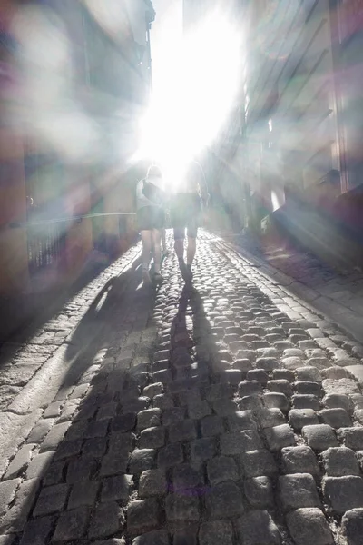 Widok Tyłu Oświetlonych Ludzi Spacerujących Wąską Brukową Uliczką Starym Mieście — Zdjęcie stockowe