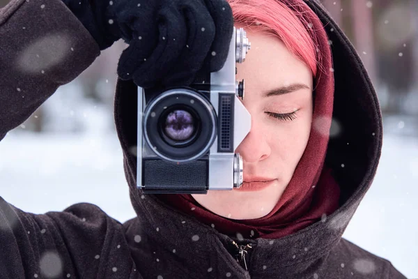 冬季森林中带着复古相机的亮粉色头发妇女的画像 — 图库照片