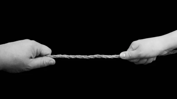 黒の背景に隔離されたロープを引く男と女の手 関係紛争の概念 — ストック写真