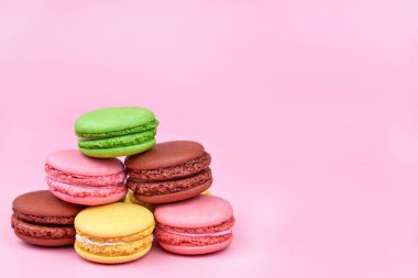 Pembe arka planda parlak moda kurabiyeler yığını, kopyalama alanı.