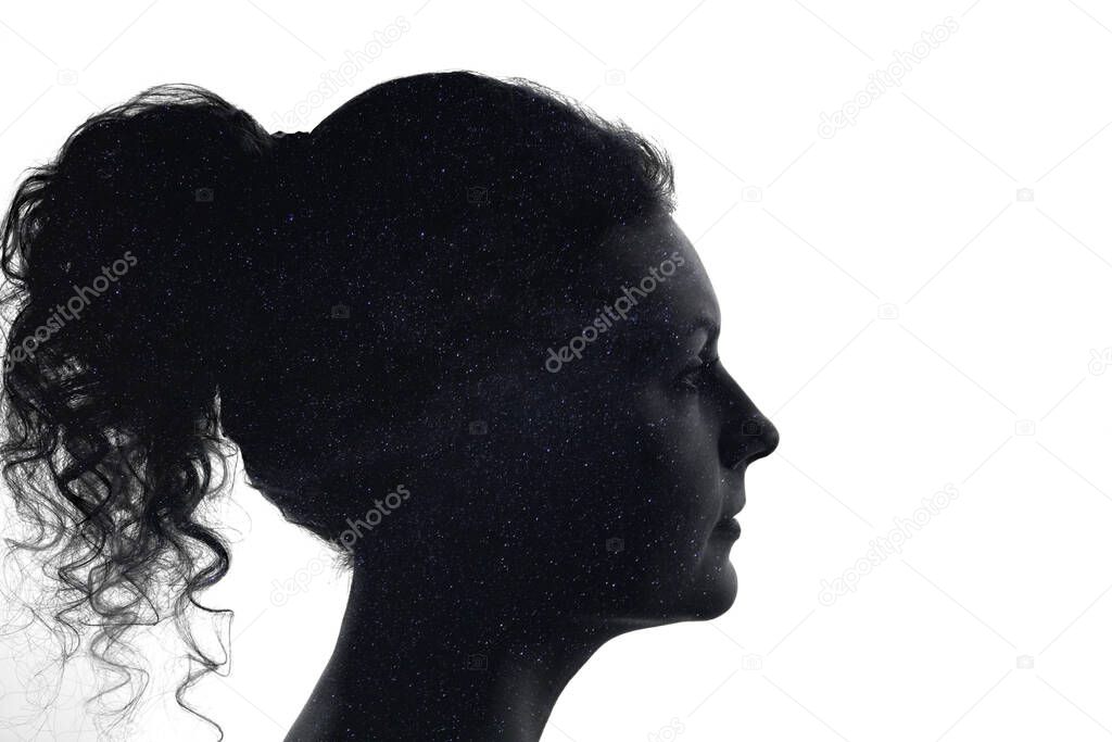 Silhouette of a woman's face filled with night starry sky, milky way, the concept of psychological stability and self-awareness.