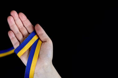 Siyah arka planda Ukrayna bayrağı renginde bir kurdele, boşluğu kopyala.