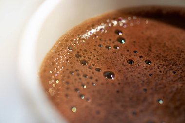 Bir fincan taze demlenmiş kahve köpüklü, makro, arka plan.