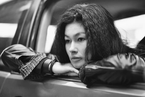 Черно Белый Снимок Молодой Женщины Выглядывающей Окна Автомобиля — стоковое фото